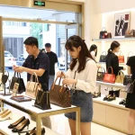 A vibrant shopping scene at a 레플리카 쇼핑몰 showcasing high-quality replica items with diverse shoppers exploring luxury fashion.